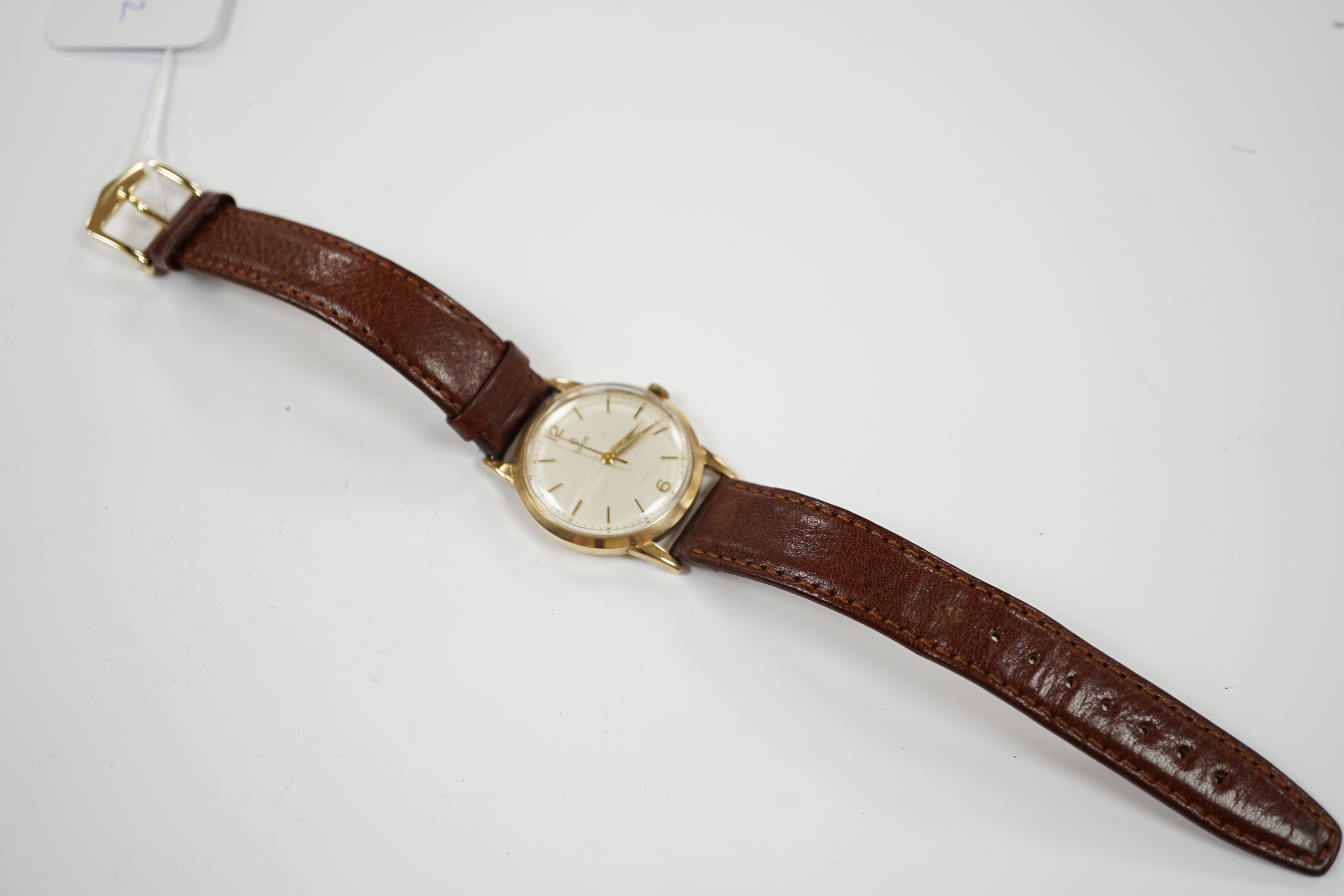 A gentleman's 1960's 9ct gold Tudor manual wind wrist watch, with baton and Arabic numerals later associated leather strap, case diameter 34mm.